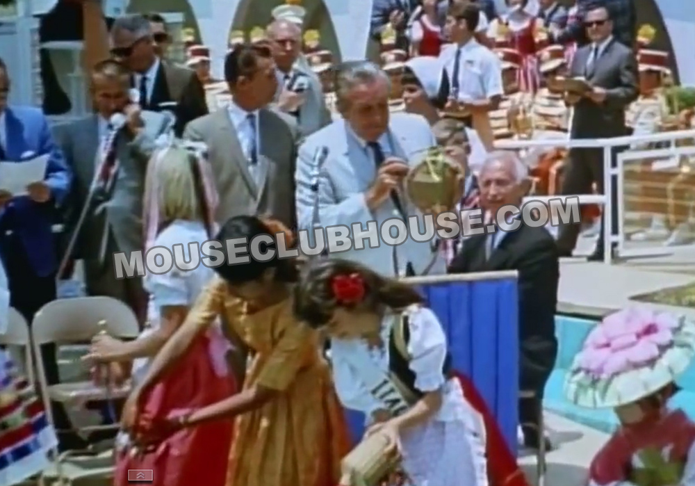 (Jack Lindquist on telephone at left) Grand opening of "it's a small world," as children pour water from their native lands, Walt Disney prepares to pour American water from Davy Crockett's canteen into the moat. Chuck Corson, whose interviews you can also hear on here, is in the background with the walkie-talkie.